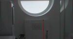 Okrúhle okno ladí z WC tlačídkom Geberit Sigma 20. 
